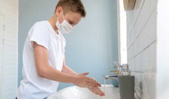 boy-wearing-medical-mask-washing-his-hands-side-view